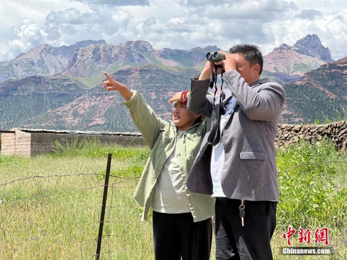 图为8月10日，义西塔生(右)和女儿一起观察野生动物。 <a target='_blank' href='/'>中新社</a>记者 李江宁 摄
